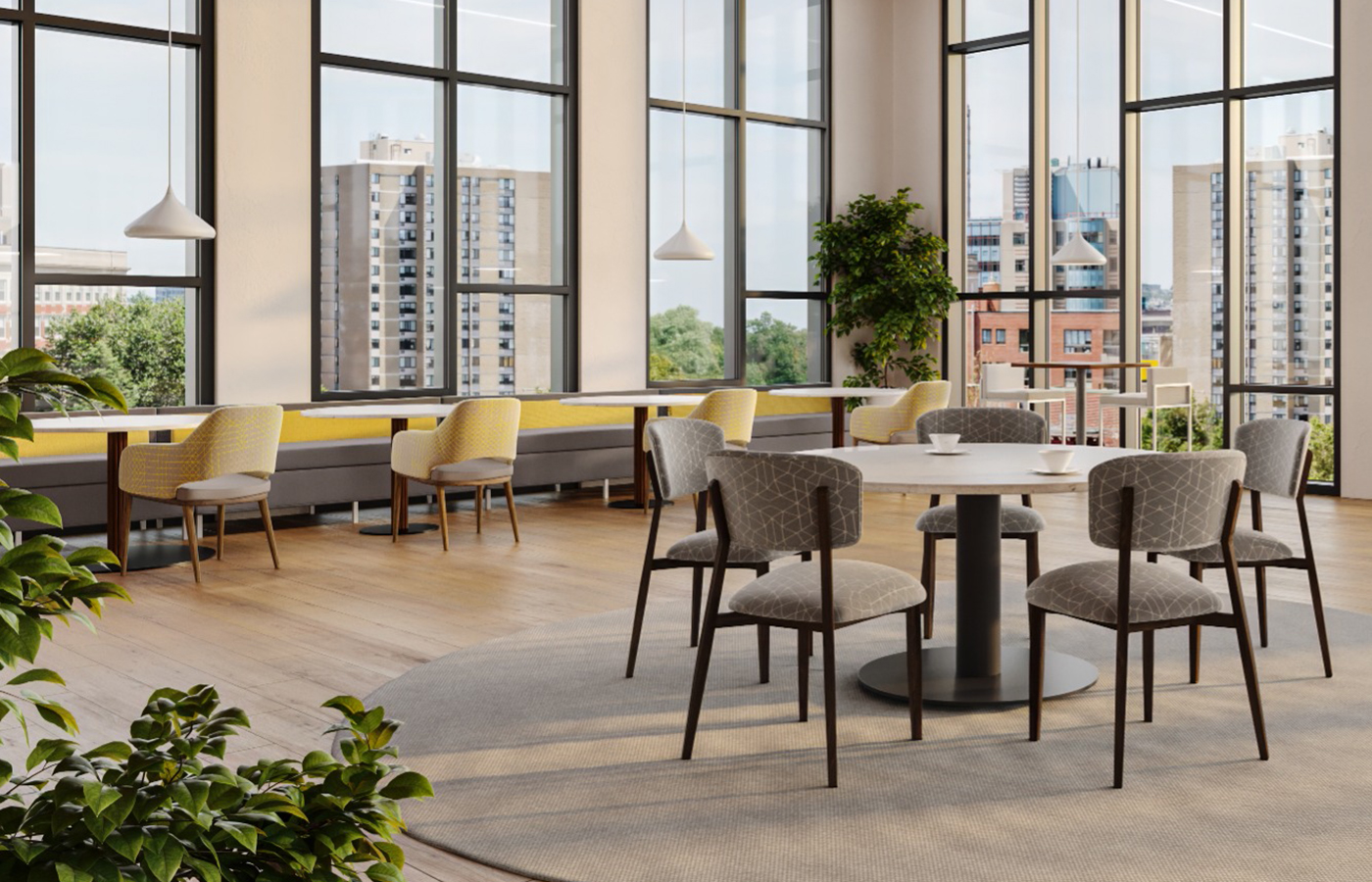 A bright modern commons with tables and seating near floor-to-ceiling windows